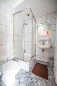 a bathroom with a shower and a toilet and a sink at Hotel Burghof in Stolberg