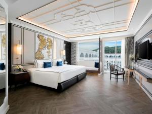 芭东海滩Mövenpick Myth Hotel Patong Phuket的一间卧室配有一张特大号床和一台电视