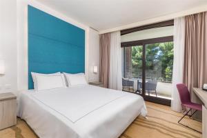 a bedroom with a large white bed and a large window at Park Plaza Histria Pula in Pula