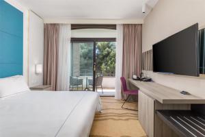 a hotel room with a bed and a flat screen tv at Park Plaza Histria Pula in Pula