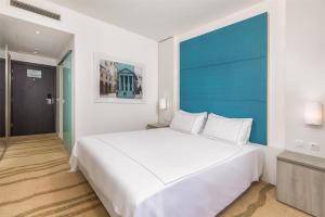 a bedroom with a large white bed with a blue headboard at Park Plaza Histria Pula in Pula