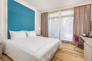 a large white bed in a room with a window at Park Plaza Histria Pula in Pula