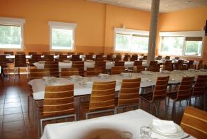 een grote eetkamer met tafels en stoelen bij Bungalows Granja Escuela Arlanzón in Arlanzón