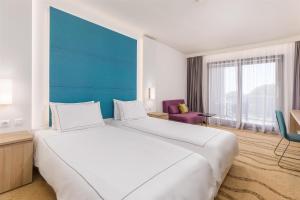 a large white bed in a hotel room at Park Plaza Histria Pula in Pula