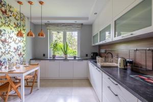 een keuken met witte kasten en een houten tafel bij Sunny Sobieszewo in Gdańsk