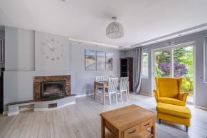 een woonkamer met een open haard en een tafel en stoelen bij Sunny Sobieszewo in Gdańsk
