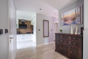 een keuken met witte kasten en een houten dressoir bij Sunny Sobieszewo in Gdańsk