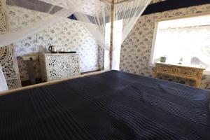 ein Schlafzimmer mit einem großen Bett in einem Zimmer mit Fenster in der Unterkunft Vanaswara in Kolad