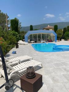 a swimming pool with two lounge chairs next to avisor at Maison in Fayence