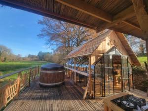 a large wooden deck with a large barrel on it at La terre du milieu 87 in Saint-Sulpice-les-Feuilles