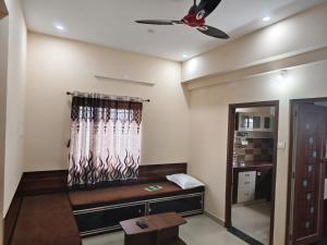 a room with a couch and a ceiling fan at Alif Serviced (Hotel) Apartments in Tambaram