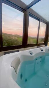 a bath tub in a room with two windows at La Siesta del Naranjo in Monesterio