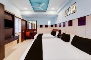 チェンナイにあるSuper Townhouse Chennai Near Airport Formerly Sai Bala Budgetのベッド2台と薄型テレビ付きのホテルの部屋