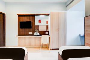チェンナイにあるSuper Townhouse Chennai Near Airport Formerly Sai Bala Budgetのベッド2台とテレビ付きの机がある寝室
