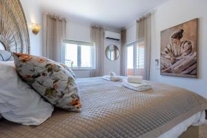 a bedroom with a large bed with two pillows on it at DeCaNa Prestige Apartment - Gated Community Algarve in Porches +19 photos
