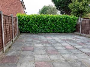a hedge in front of a brick fence at Manchester 2Bedroom Near Etihad Stadium & Coop Live Arena in Manchester