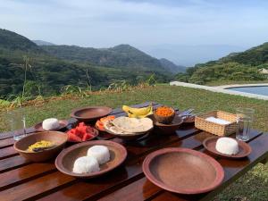 a table with bowls of food on top of a table at Royal Mountain Edge ,Knuckles in Rangala