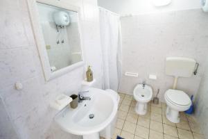 ein weißes Badezimmer mit Waschbecken und Toilette in der Unterkunft VILLETTA isola di CHIARA by Apuliahome in Capilungo + 12 Fotos