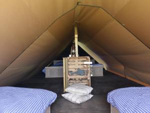 Tienda con 2 camas y silla en Beach Lodge Callantsoog near Dunes & Beach, en Callantsoog