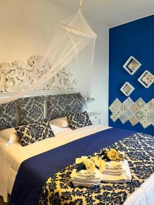 a bedroom with a bed with a blue wall at Elisabeth Seaview Apartments Sorrento Coast in Vico Equense