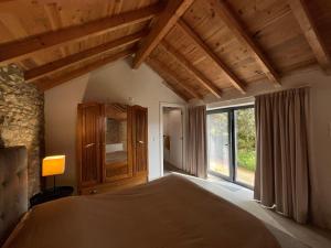 a bedroom with a bed and a large window at Casa Abílio - country house in Alvoeira
