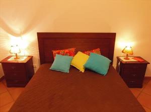 ein Schlafzimmer mit einem großen Bett mit zwei Nachttischen in der Unterkunft Monte da Fome Aguda in Odeceixe