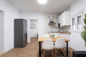 a kitchen with a table and chairs and a refrigerator at Altozano la Victoria A 2 hab in Andújar +15 photos
