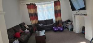 a living room with a couch and a chair and balloons at Family house in Lemington