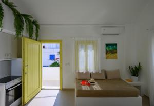 a living room with a couch and a yellow door at New Earth in Kamari