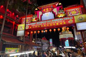 a crowd of people walking down a street at night at Malacca 3 bedroom Seri Serindit G01 in Malacca