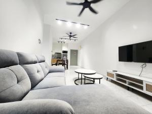 a living room with a couch and a flat screen tv at Malacca 3 bedroom Seri Serindit G01 in Malacca