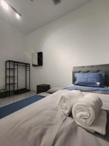 a bedroom with a bed with towels on it at Malacca 3 bedroom Seri Serindit G01 in Malacca