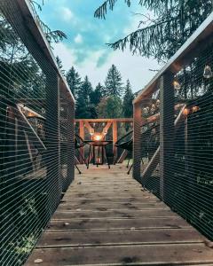Una pasarela de madera con una mesa en una terraza. en Treehouse Bystreečka, en Bystrička