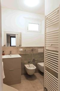 a bathroom with a sink and a tub and a toilet at rapisardi 8 in Riccione
