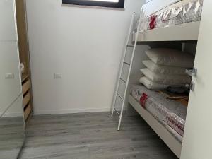 a room with a bunk bed with a ladder and pillows at rapisardi 8 in Riccione