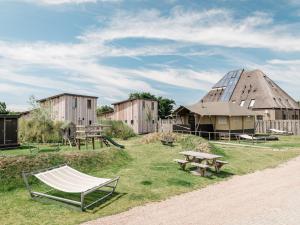 una hamaca y un edificio con una tienda de campaña en Beach Lodge Callantsoog near the Sea, en Callantsoog