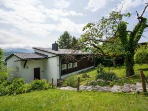 Biały dom z płotem na podwórku w obiekcie Gemütliche Ferienwohnung mit Terrasse und Seeblick w mieście Velden am Wörthersee
