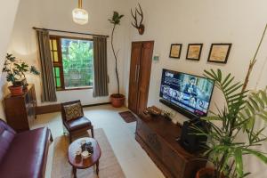uma sala de estar com um sofá e uma TV em Rajabali Villa Batu em Tlekung