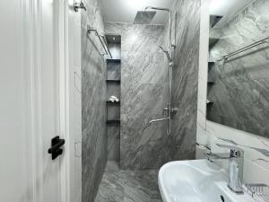 Un baño blanco con ducha y lavabo. en Квартира Новомоссковская, en Salor Bekati