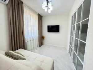 Una sala de estar con un sofá blanco y una ventana. en Квартира Новомоссковская, en Salor Bekati