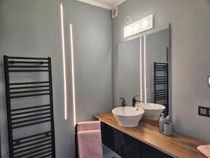 a bathroom with two sinks and a mirror at Lazy Olives in Tongeren