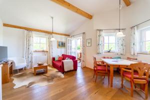 a living room with a red couch and a table at Chalet Chip-In Golf Wandern Berge in Oberuttlau +31 photos