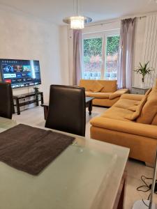a living room with orange furniture and a flat screen tv at Modern Central Apartments near Hbf & Messe Essen in Essen