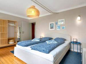 sypialnia z dwoma łóżkami i niebieskimi poduszkami w obiekcie Gemütliche Ferienwohnung mit Terrasse und Seeblick w mieście Velden am Wörthersee