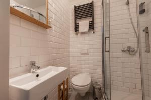 a white bathroom with a sink and a toilet at RentPlanet - Studio Rynek Ratusz in Wrocław