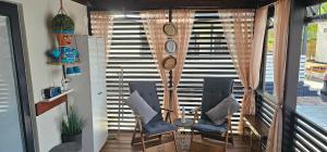 a balcony with chairs and a table and a staircase at Mobile Home Sea Shell Šime, Drage in Drage