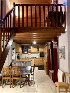 a kitchen and dining room with a wooden staircase at Chalet Parc des Écrins in Le Petit-Parcher
