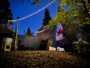 a building with two chairs and a guitar and lights at M Cabin A Frame Predeal Ciubar in Predeal