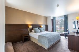 a hotel room with a bed and a window at Helgon Hotel - Lourdes Pyrénées in Lourdes +36 photos