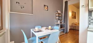 a dining room with a white table and blue chairs at Casa Tequila in Florence